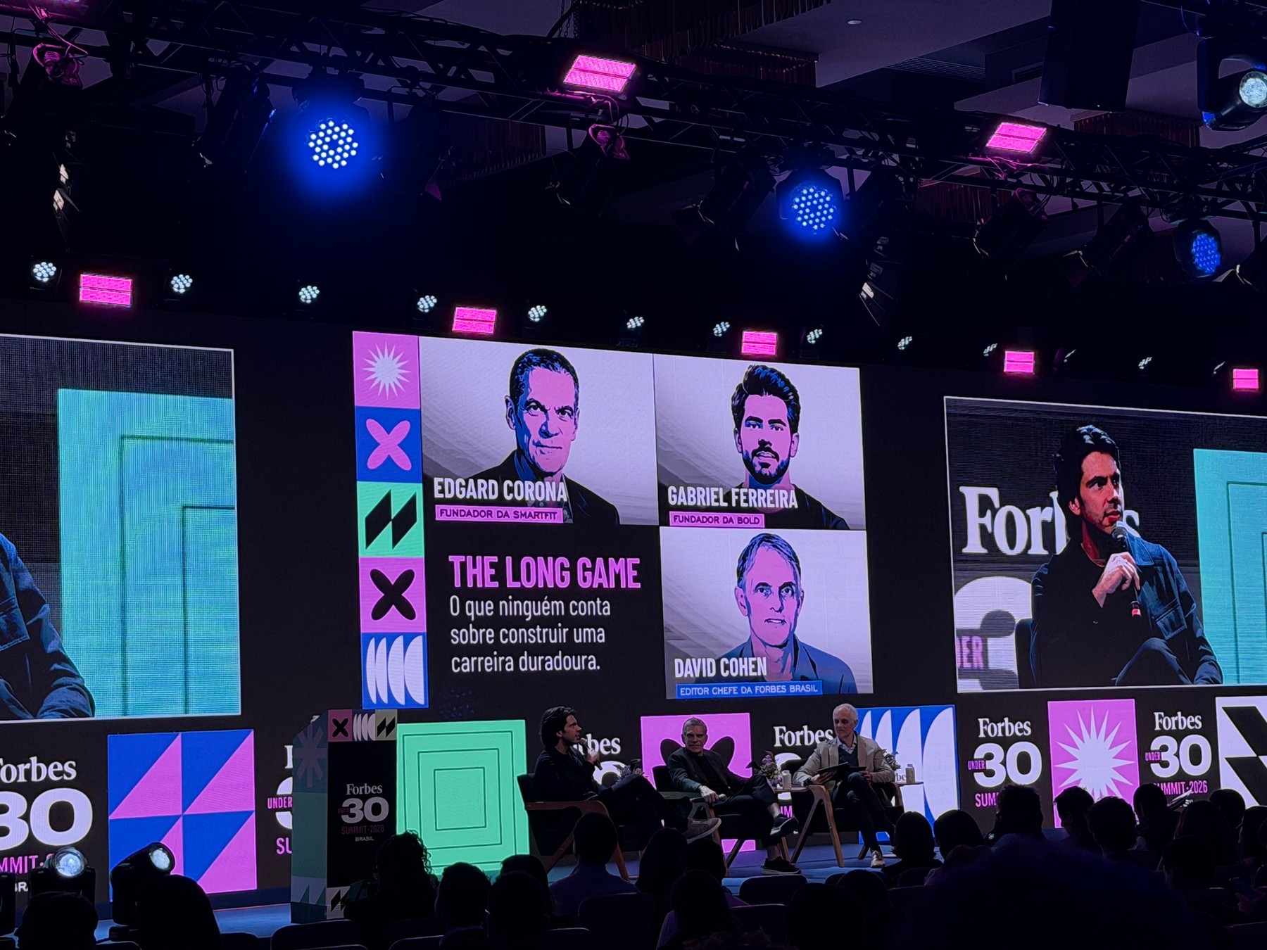Participants on stage with the title The Long Game on the screen.