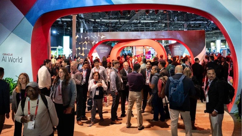 Participantes circulam na área de exposição do Oracle AI World, sob arcos vermelhos.