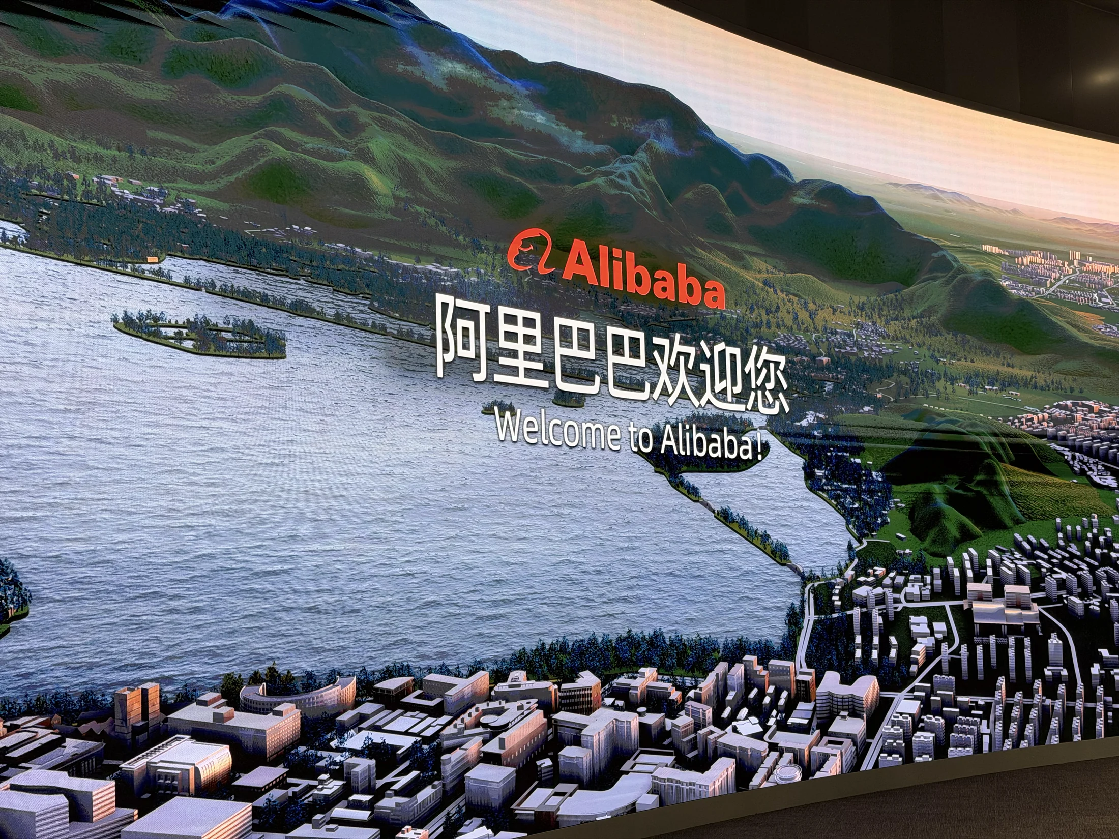 Painel de boas-vindas da Alibaba com representação do campus.