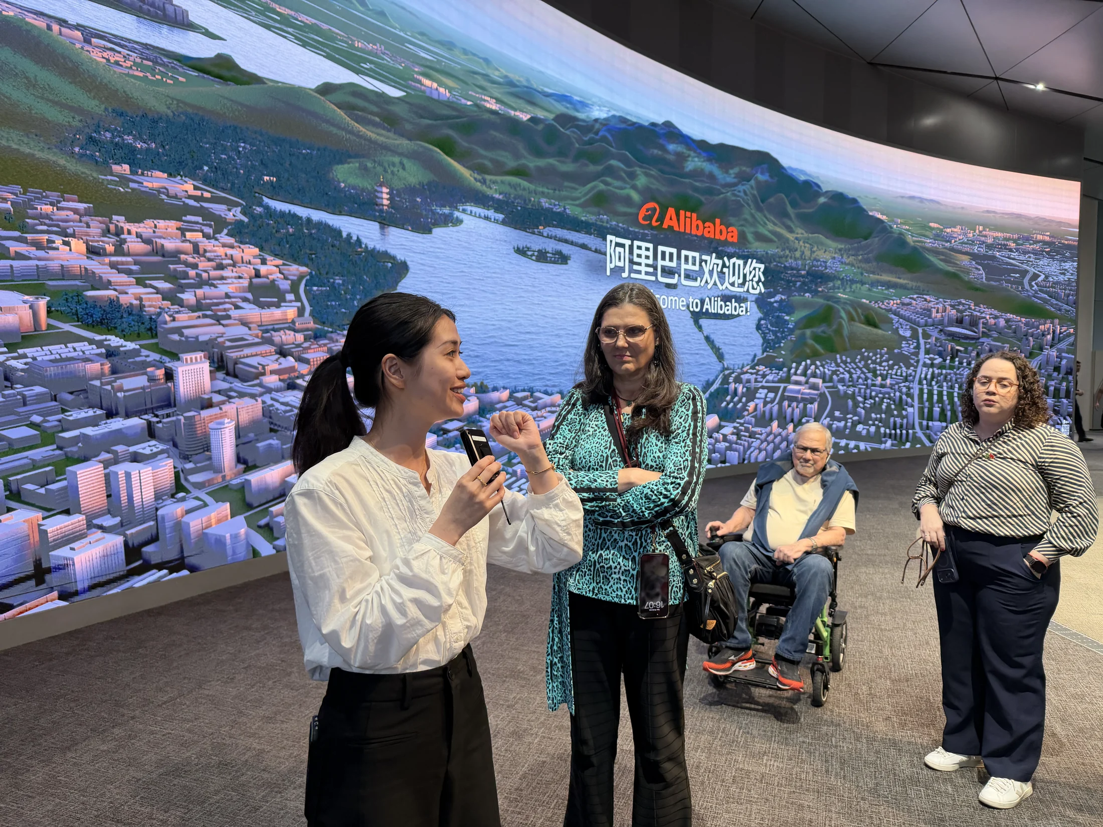 Apresentação diante do painel de boas-vindas da Alibaba.