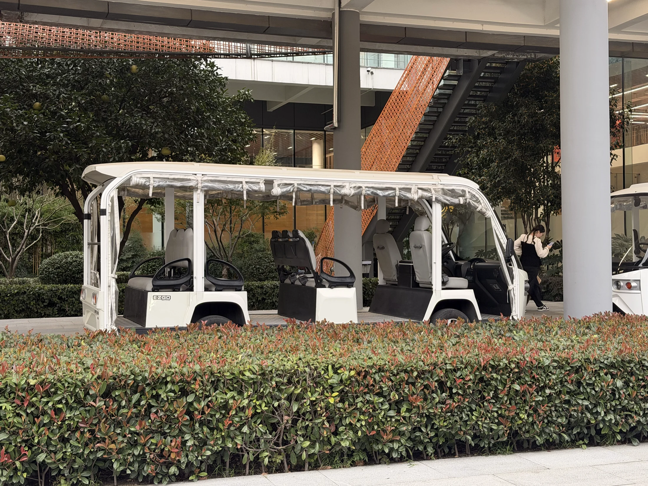 Veículo de transporte interno em uma área ajardinada.
