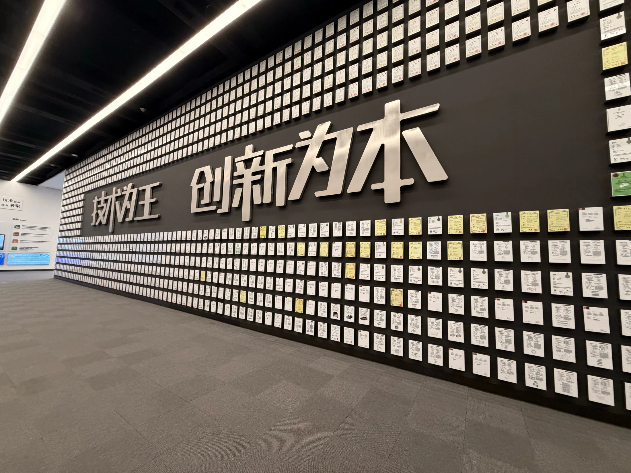 Parede de certificados na área expositiva visitada na BYD.