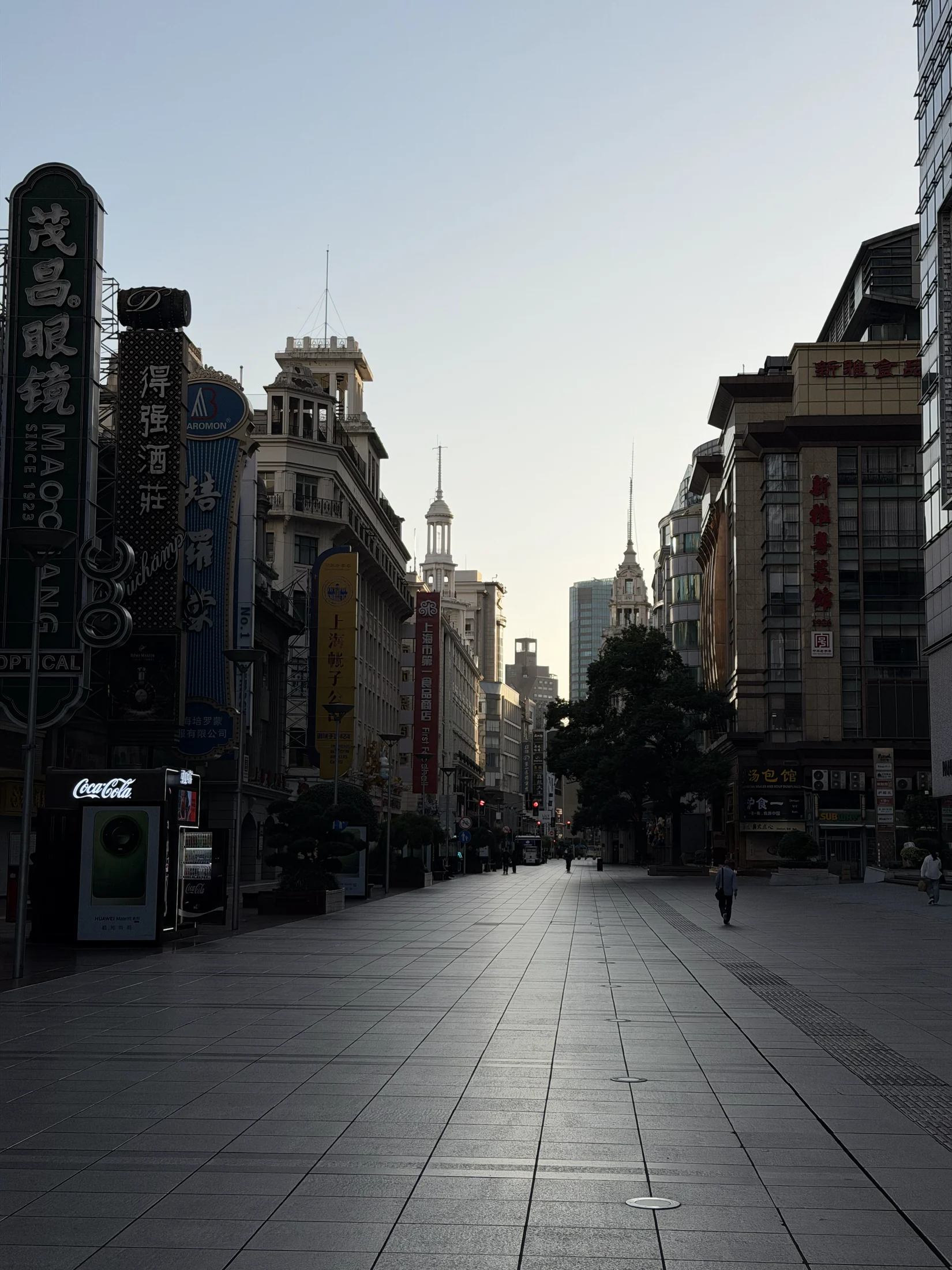 Rua comercial de Xangai, com lojas e pessoas circulando.