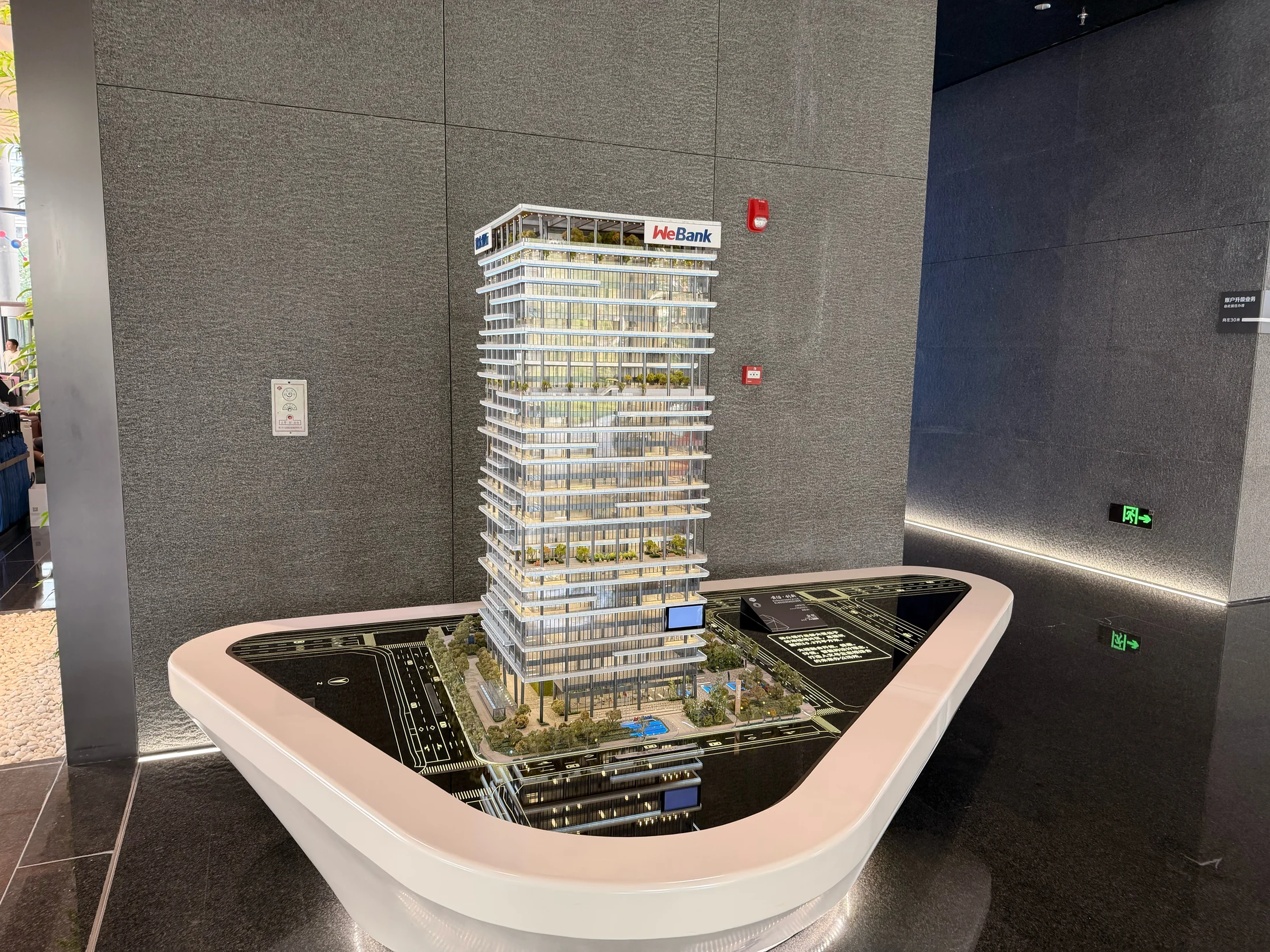 Maquete de edifício com a marca WeBank no espaço de recepção.