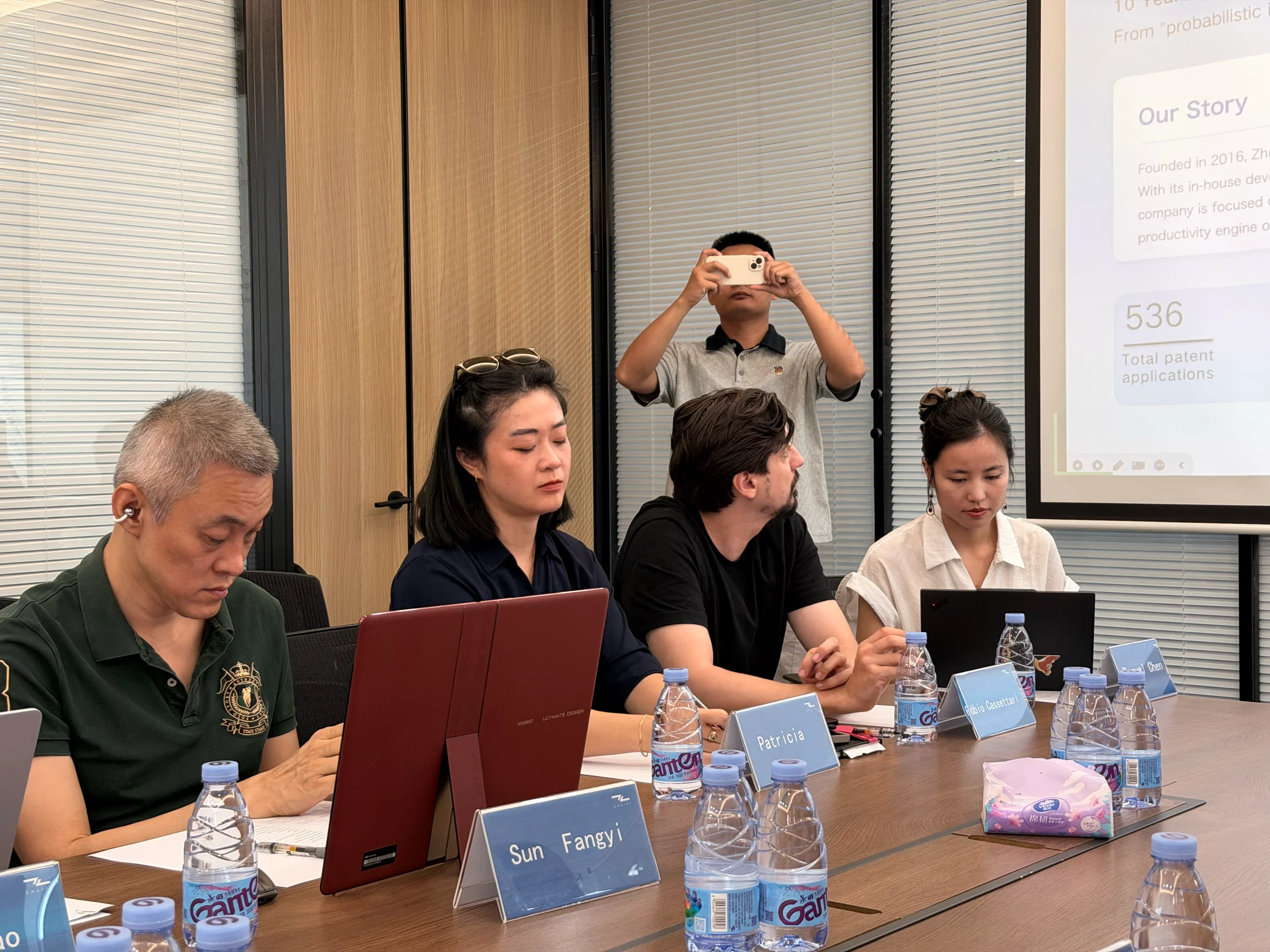 Participantes acompanham a apresentação na sala de reunião da Zhuiyi.